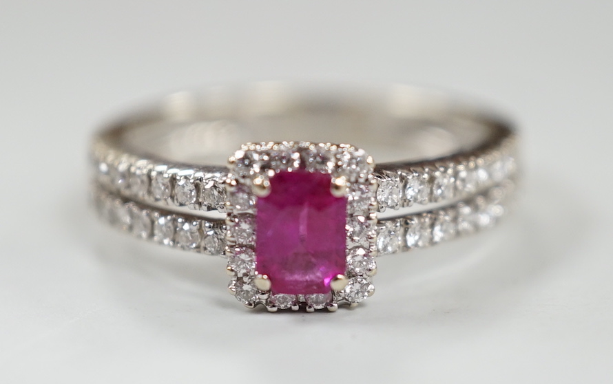 A modern 18ct white gold, single stone emerald cut ruby and diamond chip set cluster ring, with two row diamond chip set shoulders, size K, gross weight 3.3 grams.